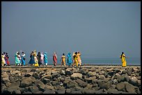 Women walking on  jetty in the distance, Elephanta Island. Mumbai, Maharashtra, India ( color)