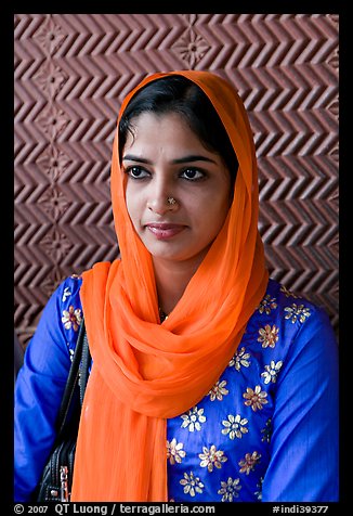 Young woman with bright scarf, in front of Rumi Sultana motifs. Fatehpur Sikri, Uttar Pradesh, India