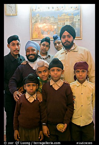 Sikh men and boys in front of picture of the Golden Temple. Bharatpur, Rajasthan, India