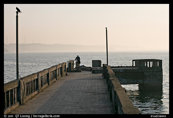 Pier with man fishing, early morning, Dona Paula. Goa, India (color)