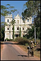 Man walking a bicycle in front of church of St John, Old Goa. Goa, India ( color)
