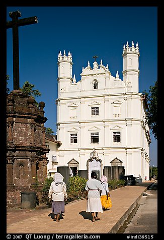 Women walking towards Church of St Francis of Assisi, afternoon, Old Goa. Goa, India (color)