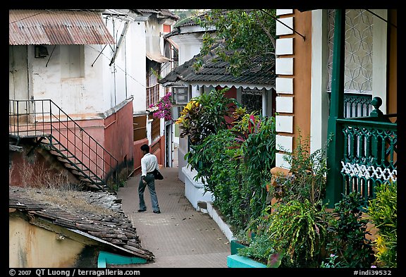 Man in alley with gardens, Panjim. Goa, India