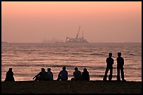 People and  off-shore platforms, Miramar Beach, sunset. Goa, India ( color)