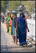 Women walking in line carrying baskets on heads. Khajuraho, Madhya Pradesh, India (color)