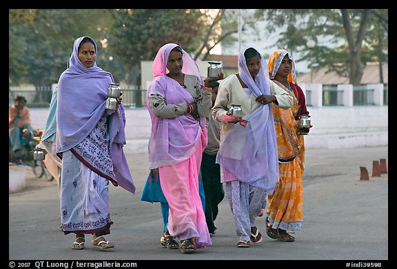 Hindu women walking in street with pots. Khajuraho, Madhya Pradesh, India (color)