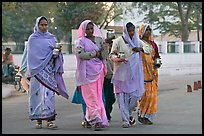 Hindu women walking in street with pots. Khajuraho, Madhya Pradesh, India (color)