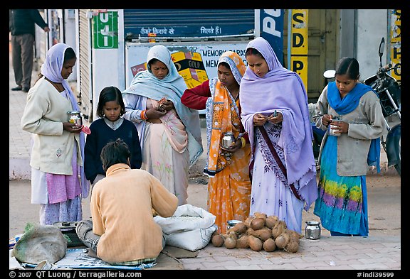 Hindu women purchasing offerings before going to temple. Khajuraho, Madhya Pradesh, India (color)