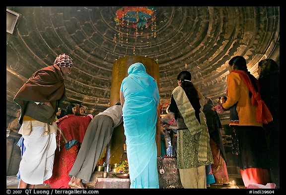 Worshipers and polished lingam inside Matangesvara temple. Khajuraho, Madhya Pradesh, India