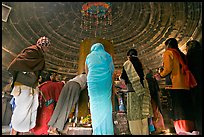 Worshipers and polished lingam inside Matangesvara temple. Khajuraho, Madhya Pradesh, India