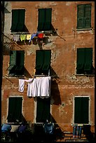Typical terra cotta facade with hanging laundry and green shutters, Vernazza. Cinque Terre, Liguria, Italy (color)