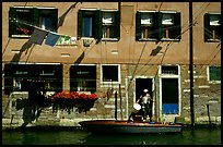 Resident stepping from his boat to his house,  Castello. Venice, Veneto, Italy ( color)