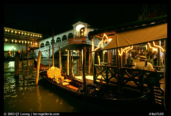Gondolier and gondola, Rialto Bridge at night. Venice, Veneto, Italy