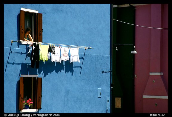 Woman hangs laundry to dry, Burano. Venice, Veneto, Italy (color)