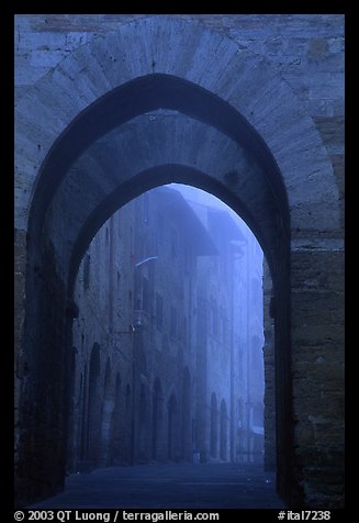 Arch at dawn in the fog. San Gimignano, Tuscany, Italy