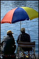 Men fishing under an colorful sun unbrella,  Agropoli. Campania, Italy (color)