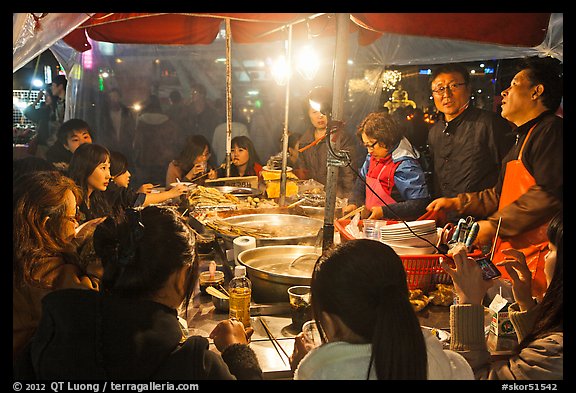 People eating noodles in a tent at night. Seoul, South Korea