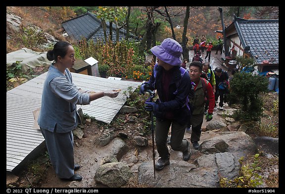 Woman giving sacred bread at Sangseonam hermitage, Namsan Mountain. Gyeongju, South Korea (color)