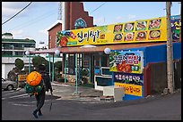 Haeneyo woman walking towards seafood restaurant. Jeju Island, South Korea (color)