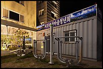 Public exercise equipment and buildings at night, Seogwipo. Jeju Island, South Korea (color)