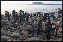 Tourists on rocky beach, Seogwipo. Jeju Island, South Korea (color)