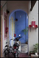 Motorcycle and altar outside townhouse. George Town, Penang, Malaysia