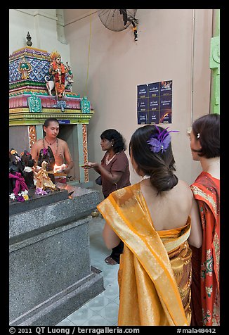 Holy man distributes fire to women, Sri Mariamman Temple. George Town, Penang, Malaysia