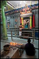 Holy man tends to altar, Hindu temple. George Town, Penang, Malaysia