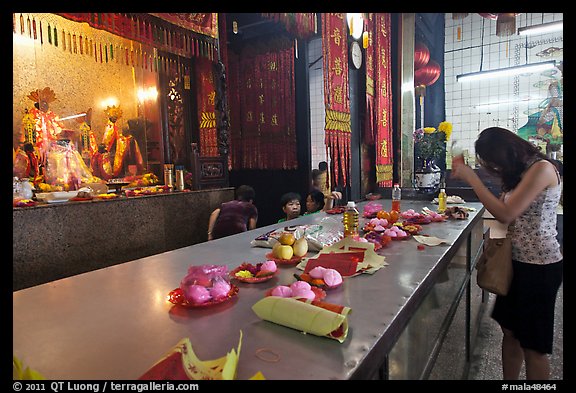 Woman Worshiping inside Chinese temple. George Town, Penang, Malaysia (color)