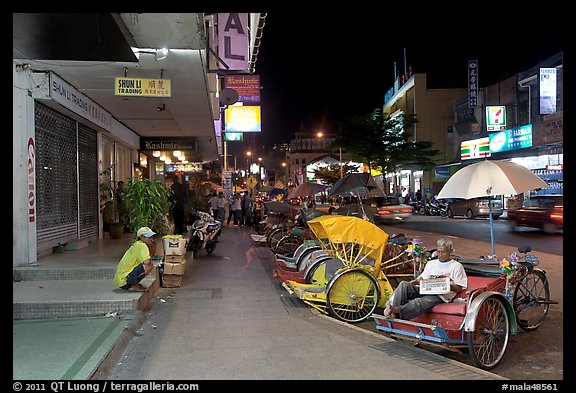 Cycle rickshaws lined on street at night. George Town, Penang, Malaysia