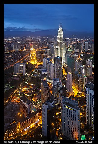 Skyscrappers dominated by Petronas Towers at night. Kuala Lumpur, Malaysia