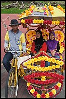 Rider and two women passengers, bicycle rickshaw. Malacca City, Malaysia