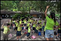 Schoolchildren doing gymnastics in  Singapore Botanical Gardens. Singapore (color)