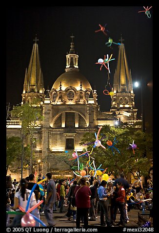 Children play with inflated balloons behind the Cathedral by night. Guadalajara, Jalisco, Mexico