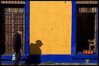 Elderly man walking along a colorful wall, Tlaquepaque. Jalisco, Mexico