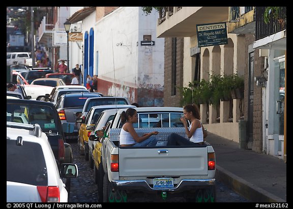 Young women riding in the back of a pick-up truck in a busy street, Puerto Vallarta, Jalisco. Jalisco, Mexico (color)