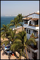 White adobe building with red tile roof,  palm trees and ocean, Puerto Vallarta, Jalisco. Jalisco, Mexico ( color)