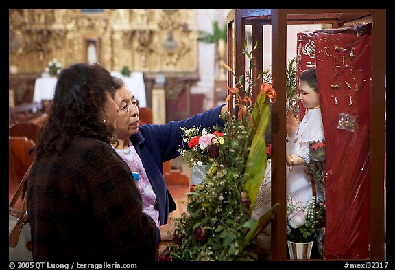 Women placing flowers in front of a Saint figure. Zacatecas, Mexico (color)