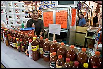 Woman at a booth with lots of chili bottles in Mercado Hidalgo. Guanajuato, Mexico