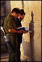 Young soldier and orthodox jew reading prayer  books at the Western Wall. Jerusalem, Israel (color)