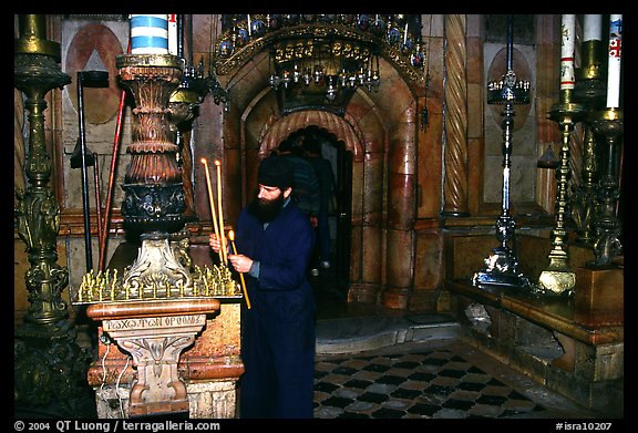 Christian Orthodox priest lighting candles. Jerusalem, Israel (color)