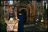 Christian Orthodox priest lighting candles. Jerusalem, Israel