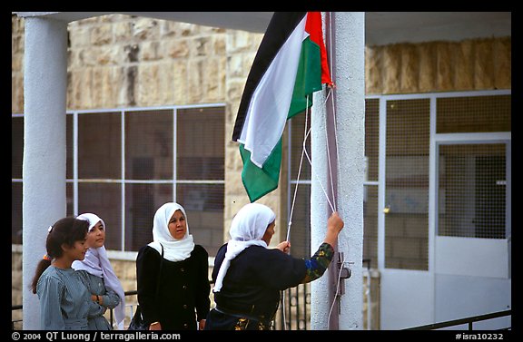Women raise the Palestian flag at a school in East Jerusalem. Jerusalem, Israel (color)