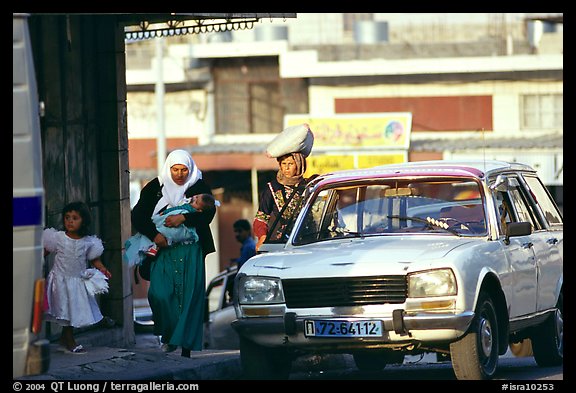 Women next to an old French Peugeot car, Hebron. West Bank, Occupied Territories (Israel)