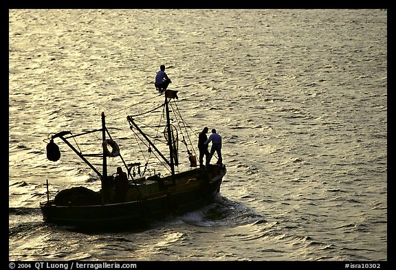 Small fishing boat silhouetted, late afternoon, Akko (Acre). Israel (color)
