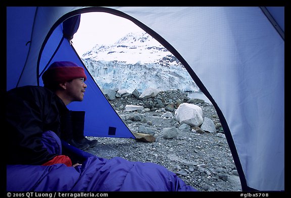 Visitor in  tent looking outside to Lamplugh Glacier. Glacier Bay National Park, Alaska