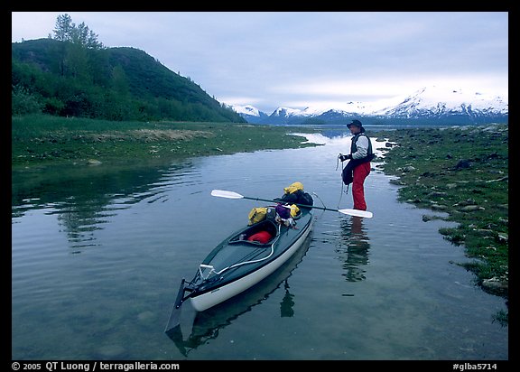 Kayaker tows kayak into a shallow tidal channel into Scidmore Bay. Glacier Bay National Park, Alaska (color)