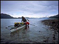 Kayaker getting into the kayak,  Muir Inlet. Glacier Bay National Park, Alaska (color)
