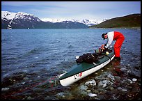 Kayaker tying up gear on top of the kayak,  East Arm. Glacier Bay National Park, Alaska (color)