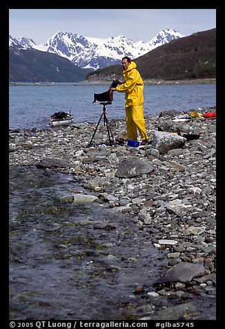Large format photographer wearing kayaking gear on a beach in East Arm. Glacier Bay National Park, Alaska